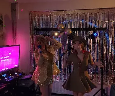 Twee vriendinnen die in een versierd huis karaoke thuis huren