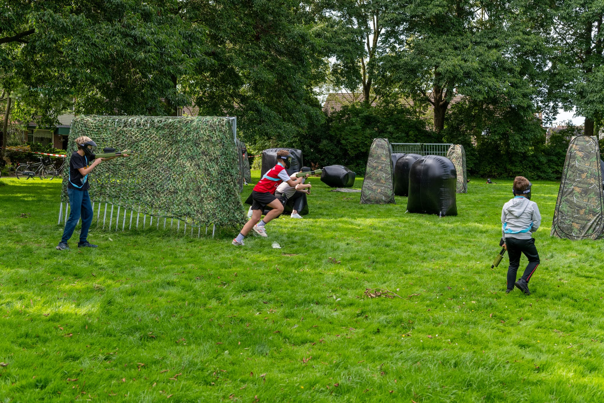 Doet paintball pijn tactiek om minder geraakt te worden kinderen paintballen op een veldje met obstakels