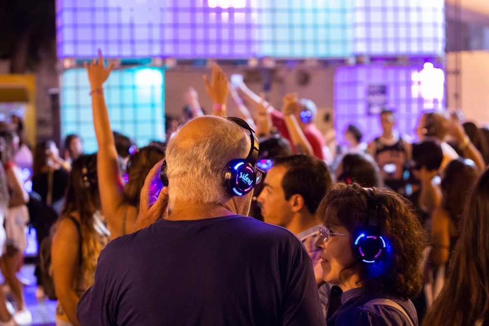 Wat is een silent disco en hoe werkt het alle informatie een feest met veel mensen, silent disco en kanalen