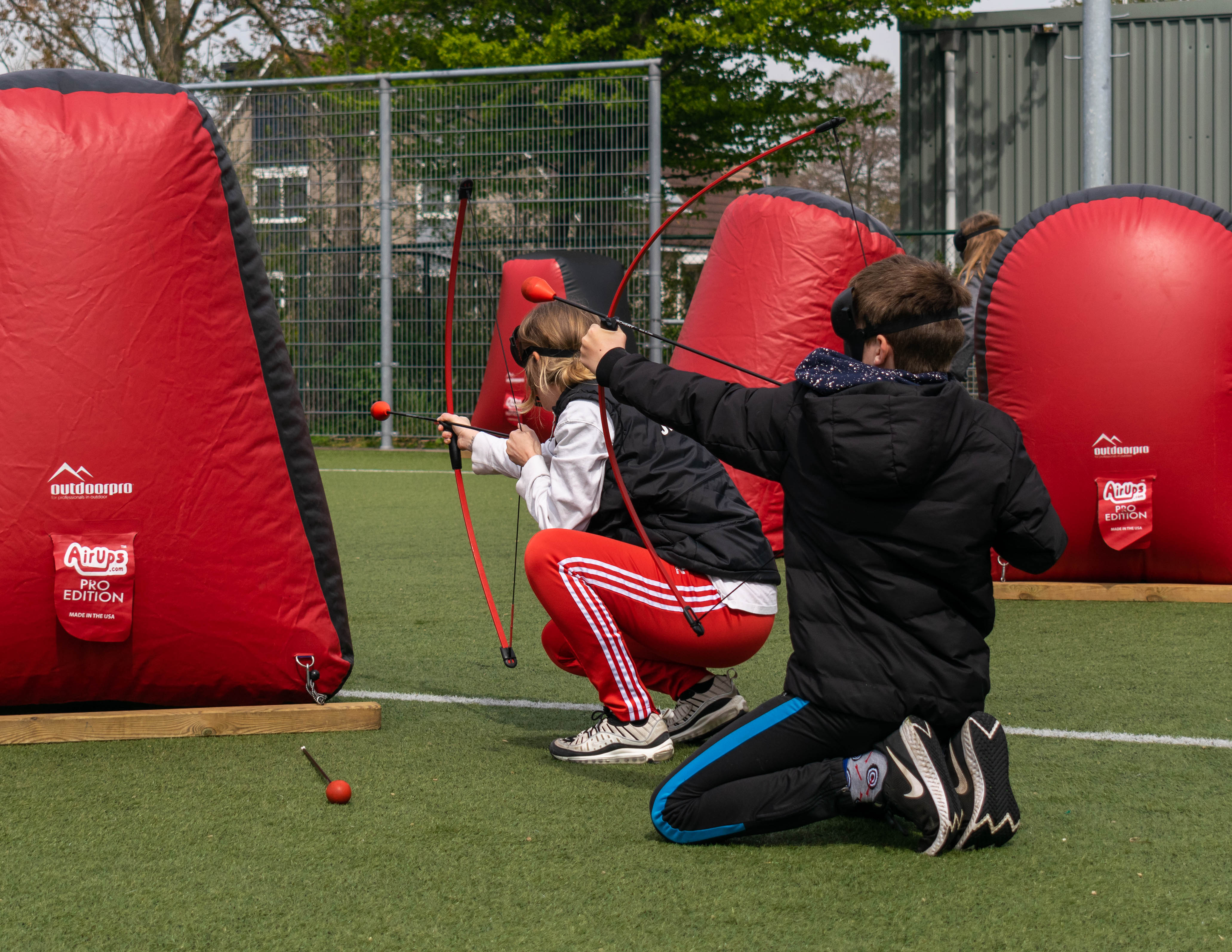 Archery tag speelveld  met obstakels en camouflagenetten voor een kinderfeestje