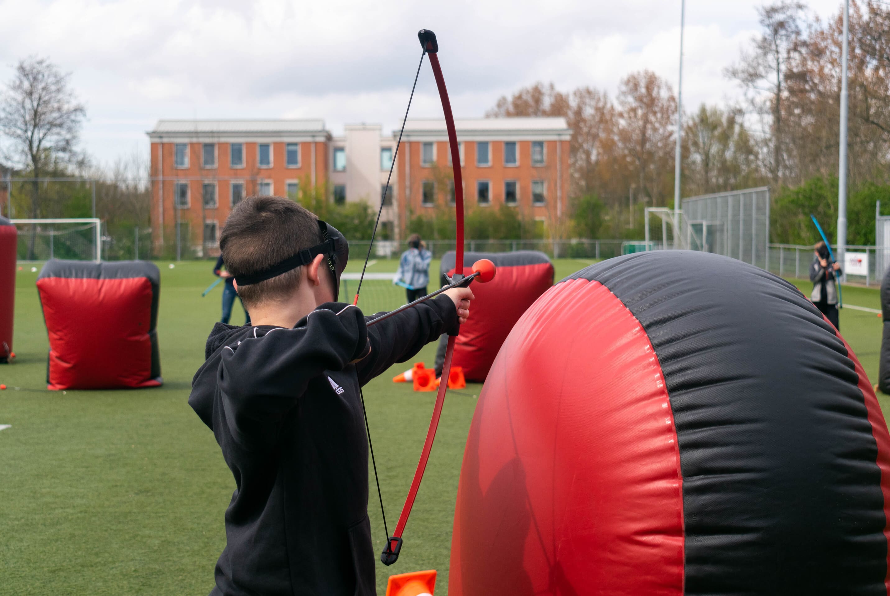 Archery tag spelvarianten spelvormen een jongen die een boog richt