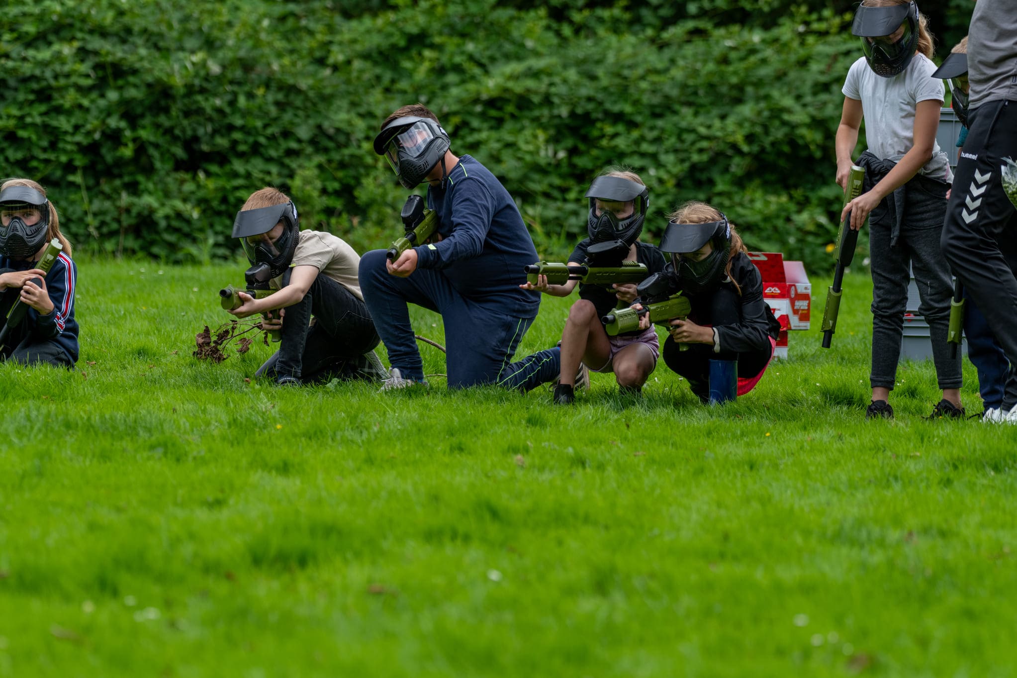 Doet paintball pijn op een veldje met drie spelers en een paintballgun en maskers