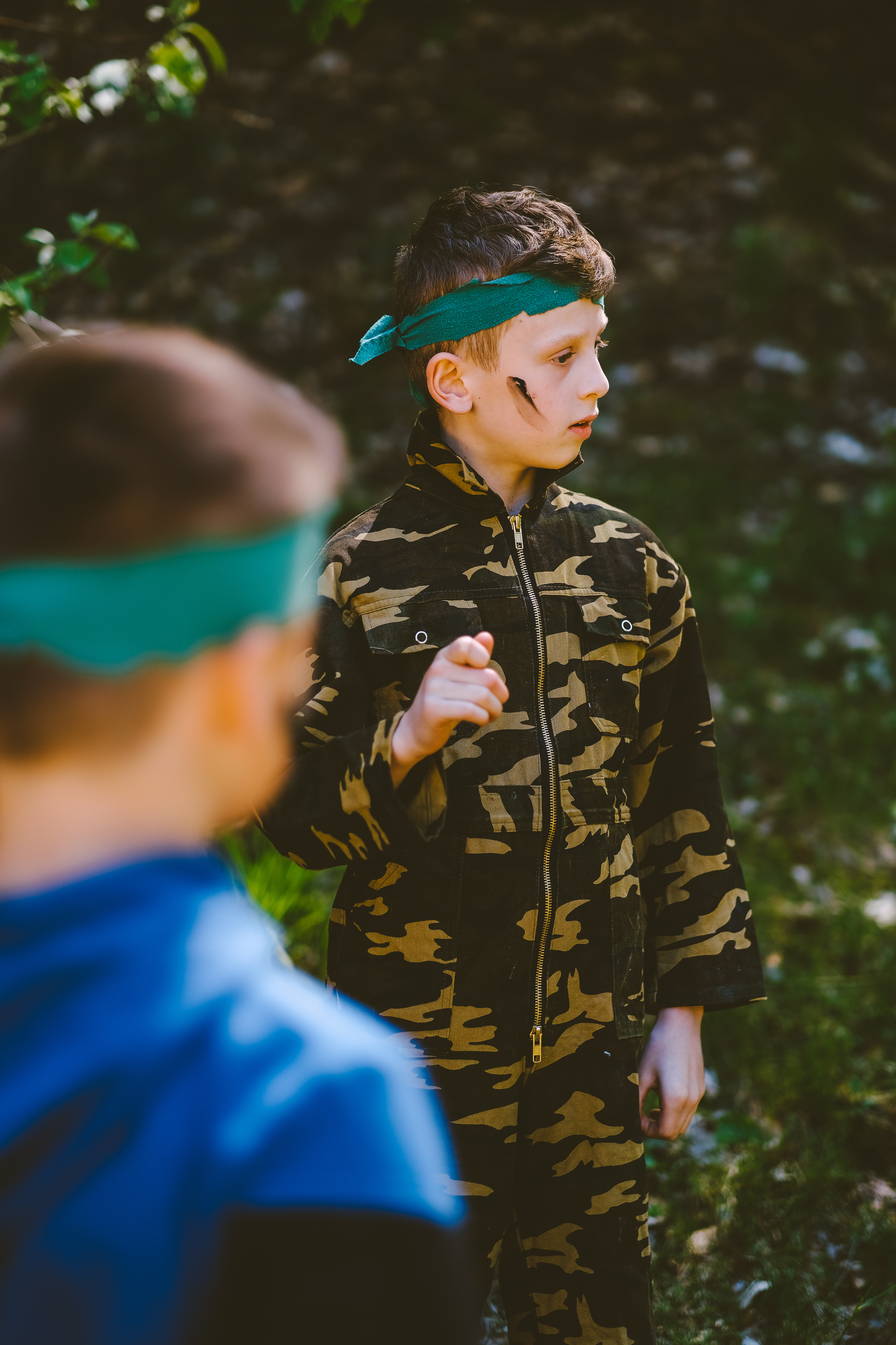 Kinderen die op een kinderfeestje lasergame spelen in het bos buiten