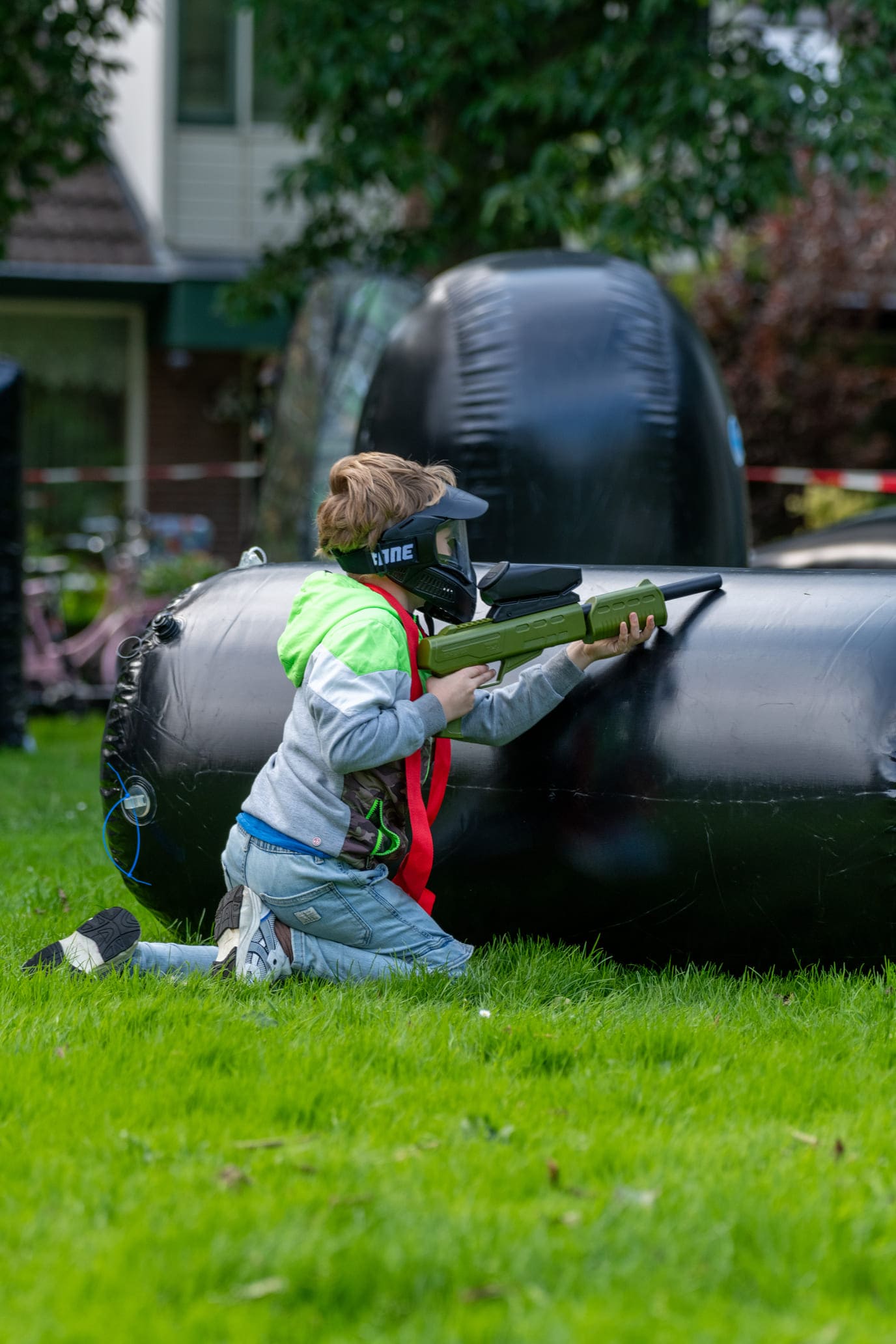 Paintball kinderfeestje organiseren tips voor voorbereiding kind met paintballgun op grasveldje