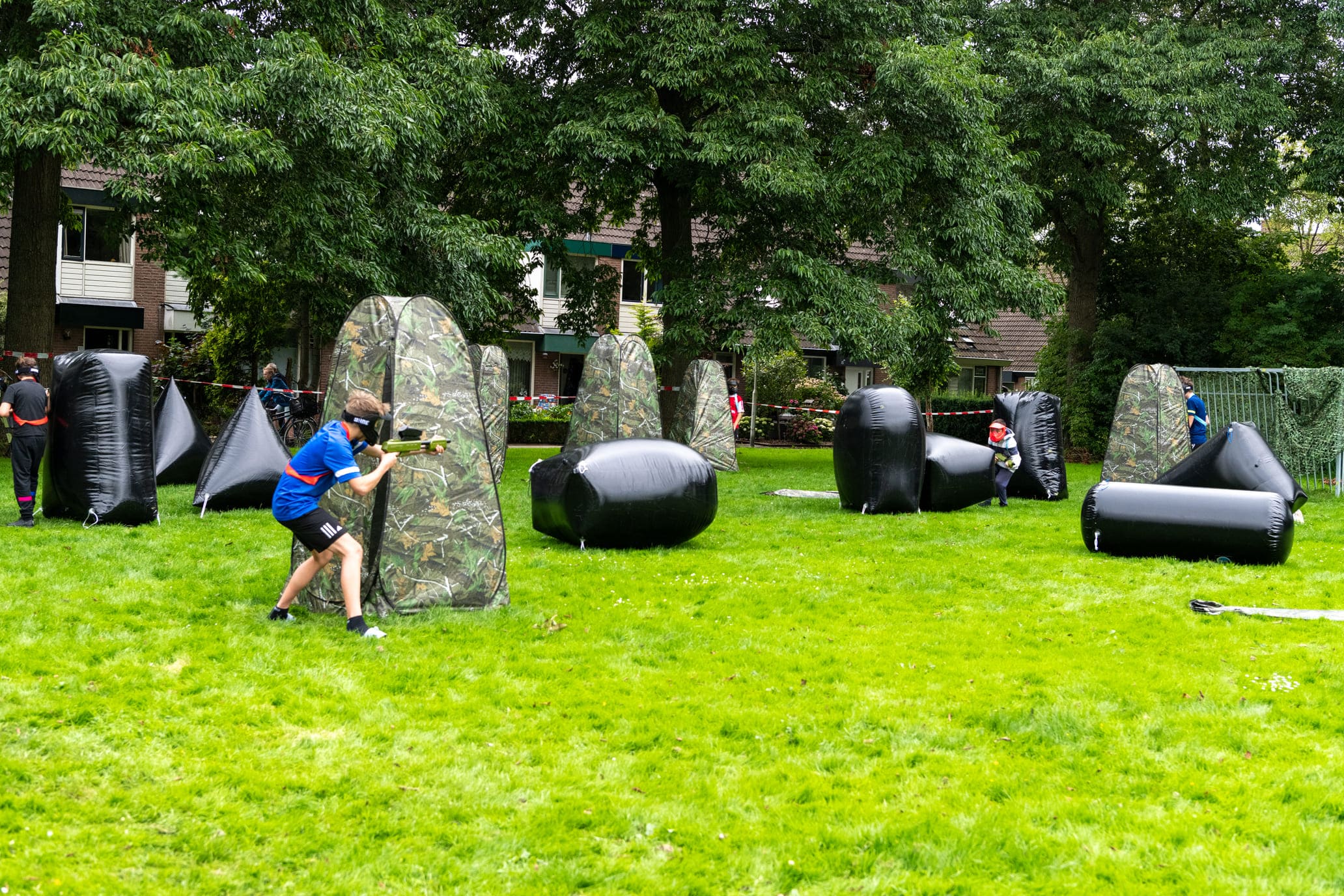 Kinderen op een kinderfeestje die paintballen en een spelvorm spelen die geschikt voor ze is