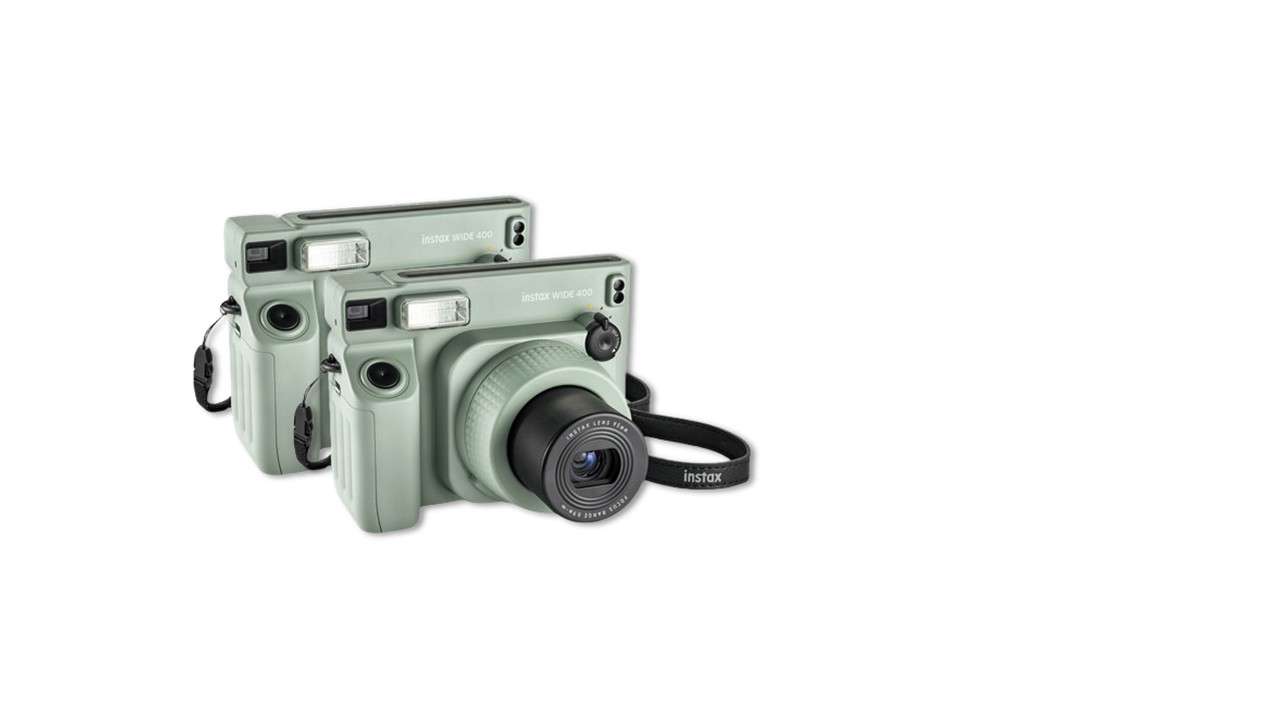 Een polaroid camera met fotopapier en foto's van een feestje